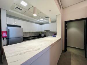 a large kitchen with white counter tops and a refrigerator at OVAL TOWER in Dubai