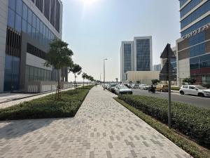 a sidewalk in a city with cars parked on the street at OVAL TOWER in Dubai