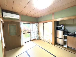 an empty room with a kitchen with a microwave at Inn Unkai no Sato no Yado 民宿 雲海の里の宿 in Nosegawa