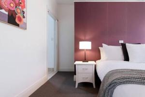 a bedroom with two beds and a lamp on a night stand at Homely Cottage: Near the City Wifi & Parking in Newstead