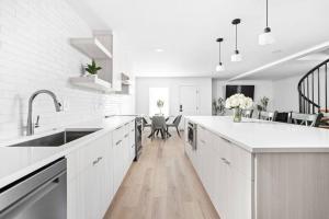 a white kitchen with white counters and a dining room at Evans-Clark Manor in Indianapolis