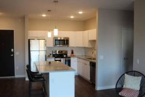 a kitchen with white cabinets and a kitchen island with chairs at Onsite coffee bar just mins to Jack Thrice Stadium in Ames +22 photos
