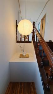 a chandelier hanging from a staircase with a cup on a table at Soban Stay in Busan