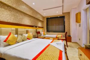 1 dormitorio con 2 camas y ventana en The Ashoka Hotel, en Indore