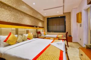 a bedroom with two beds and a window at The Ashoka Hotel in Indore