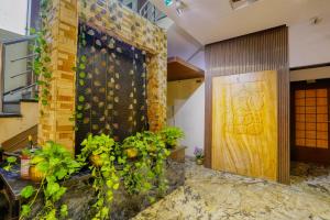 un hall avec des plantes sur le mur et une porte dans l'établissement The Ashoka Hotel, à Indore