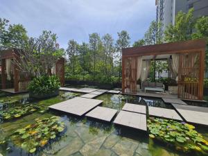 Un jardín con un estanque con nenúfares. en l Brand New Condo l I-Muslim Guesthouse Kuala Lumpur, en Kuala Lumpur