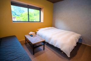 a bedroom with a bed and a table with a window at LOCOMOTION COFFEE AND BED in Tateyama