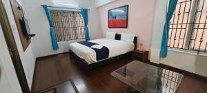 a bedroom with a bed and a glass table at SAVIS home stay in Ooty