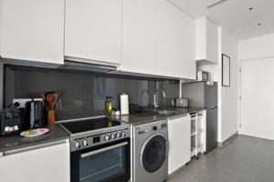 a kitchen with a stove and a dishwasher at Silkhaus Modern Studio with Access to Private Beach in Abu Dhabi