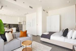 um quarto com uma cama, um sofá e uma cozinha em Silkhaus Studio with Private Beach and Sea View em Abu Dhabi