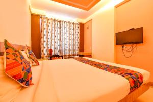 een slaapkamer met een groot bed en een tv aan de muur bij FabHotel Apex Intercontinental in Jaipur