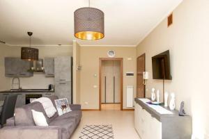 a living room with a couch and a kitchen at Comfort in Malpensa-Rho Fiera Milano 15 min in Legnano
