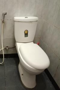 a white toilet with a sticker on the side of it at OYO 93628 Scorpion Guest House & Beach in Tulungagung