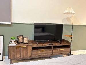 a flat screen tv sitting on top of a wooden entertainment center at Paradigm Residence Studio 4pax 2King bed Netflix WiFi in Johor Bahru