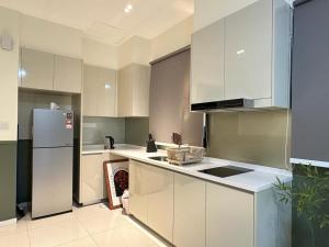 cocina con armarios blancos y nevera en Paradigm Residence Studio 4pax 2King bed Netflix WiFi en Johor Bahru
