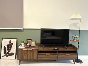 una sala de estar con TV en un centro de entretenimiento de madera en Paradigm Residence Studio 4pax 2King bed Netflix WiFi en Johor Bahru