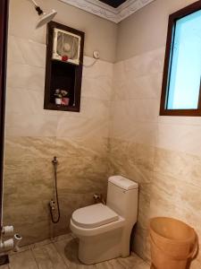 a bathroom with a toilet and a window at Luxury Living Rooms in Karachi