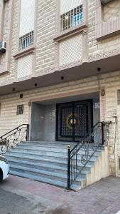 a building with stairs and a door with a gate at شقة بموقع مميز قريبة من الحرم في قلب المدينة وبجانبها جميع الخدمات in Al Madinah