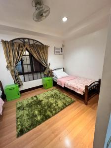 sypialnia z 2 łóżkami i zielonym dywanem w obiekcie Family House in Cagayan de Oro City w mieście Cagayan de Oro