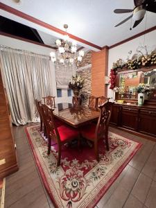 a dining room with a table and chairs on a rug at Family House in Cagayan de Oro City in Cagayan de Oro