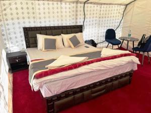 a bed in a tent with two chairs and a table at Himalayan Hideout in Hundar
