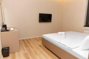 ein Schlafzimmer mit einem Bett mit zwei Handtüchern darauf in der Unterkunft Aston Hotel in Aqtau