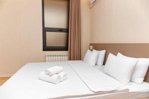 una camera d'albergo con due asciugamani arrotolati su un letto di Aston Hotel ad Aqtau