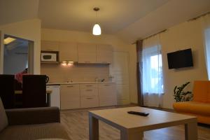 a living room with a kitchen and a table at Apartamentai Vilma in Palanga