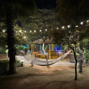 a hammock in a park with a playground at night at Shivjot Farm & Resort Panchkula in Panchkula