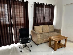 a living room with a couch and a chair and a table at Blissful Stays in Pune