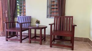 Dos sillas y una mesa con una planta. en Serei Saophoan Villa Homestay en Sisophon 