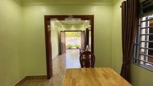 a dining room with a wooden table and a doorway at Serei Saophoan Villa Homestay in Sisophon 