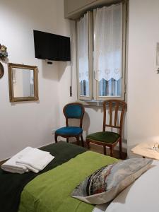 ヴェローナにあるB&B Mavipagiのベッドルーム1室(椅子2脚、ベッド1台、テレビ付)