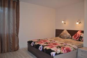 a bedroom with a bed with roses on it at Apartamentai Vilma in Palanga
