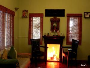 a living room with a fire in a fireplace at LEELA's COUNTRY HOUSE in Kodaikānāl +34 photos
