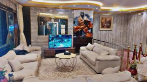een woonkamer met witte banken en een flatscreen-tv bij درر بيان in Hafr Al Baten