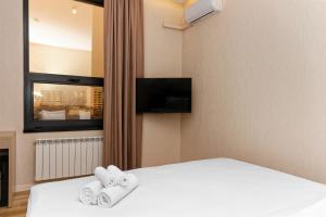 a hotel room with a bed with two towels at Aston Hotel in Aktau