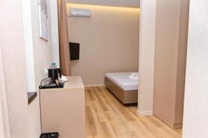 a small room with a bed and a mirror at Aston Hotel in Aktau