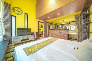ein Schlafzimmer mit einem großen weißen Bett und einem TV in der Unterkunft Cat Sky Country Homestay in Xingjian
