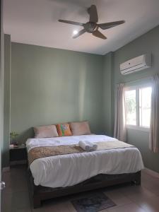 a bedroom with a bed with a ceiling fan at บ้านพักในสวนK&N2 