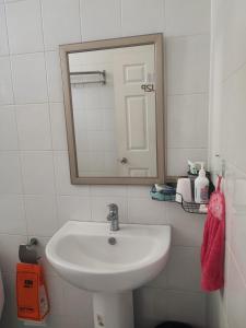 a bathroom with a white sink and a mirror at บ้านพักในสวนK&N2 