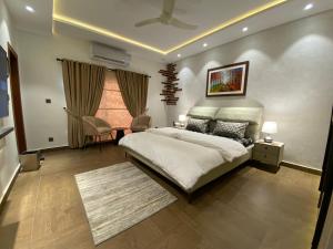 a bedroom with a large white bed and a window at Firefly Retreat-your home away from home in Rawalpindi