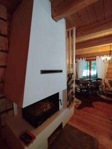 a fireplace in the living room of a log cabin at domek w zaczarowanym lesie in Istebna