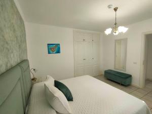 1 dormitorio con 1 cama blanca y 1 sofá verde en Rocas del Mar 327, en Costa del Silencio 15 fotos más