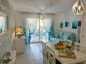 Una sala de estar con un sofá azul y una mesa. en Rocas del Mar 327, en Costa del Silencio