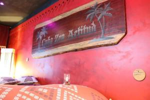 une chambre dotée d'un mur rouge et d'un panneau. dans l'établissement Apartment Cuba Zen Actitud, à Mouscron