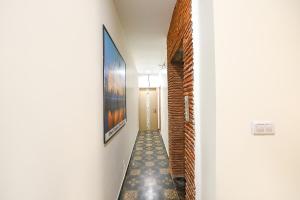 FabHotel Nirvana Grand By IO في أمريتسار: ممر فيه لوحة على الحائط بجانب باب