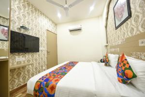 a bedroom with a bed and a tv on a wall at FabHotel Nirvana Grand By IO in Amritsar