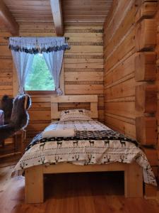 a bedroom with a bed in a log cabin at domek w zaczarowanym lesie in Istebna